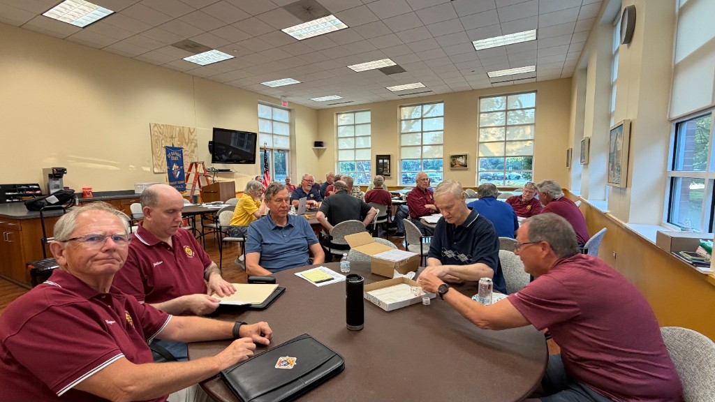 Council members gathered around tables at a monthly meeting